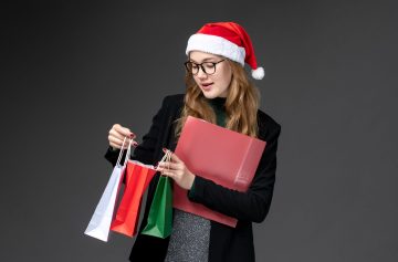 vista-frontal-de-las-mujeres-jovenes-con-paquetes-de-regalos-de-navidad-de-ano-nuevo-de-regalo-de-pared-oscura